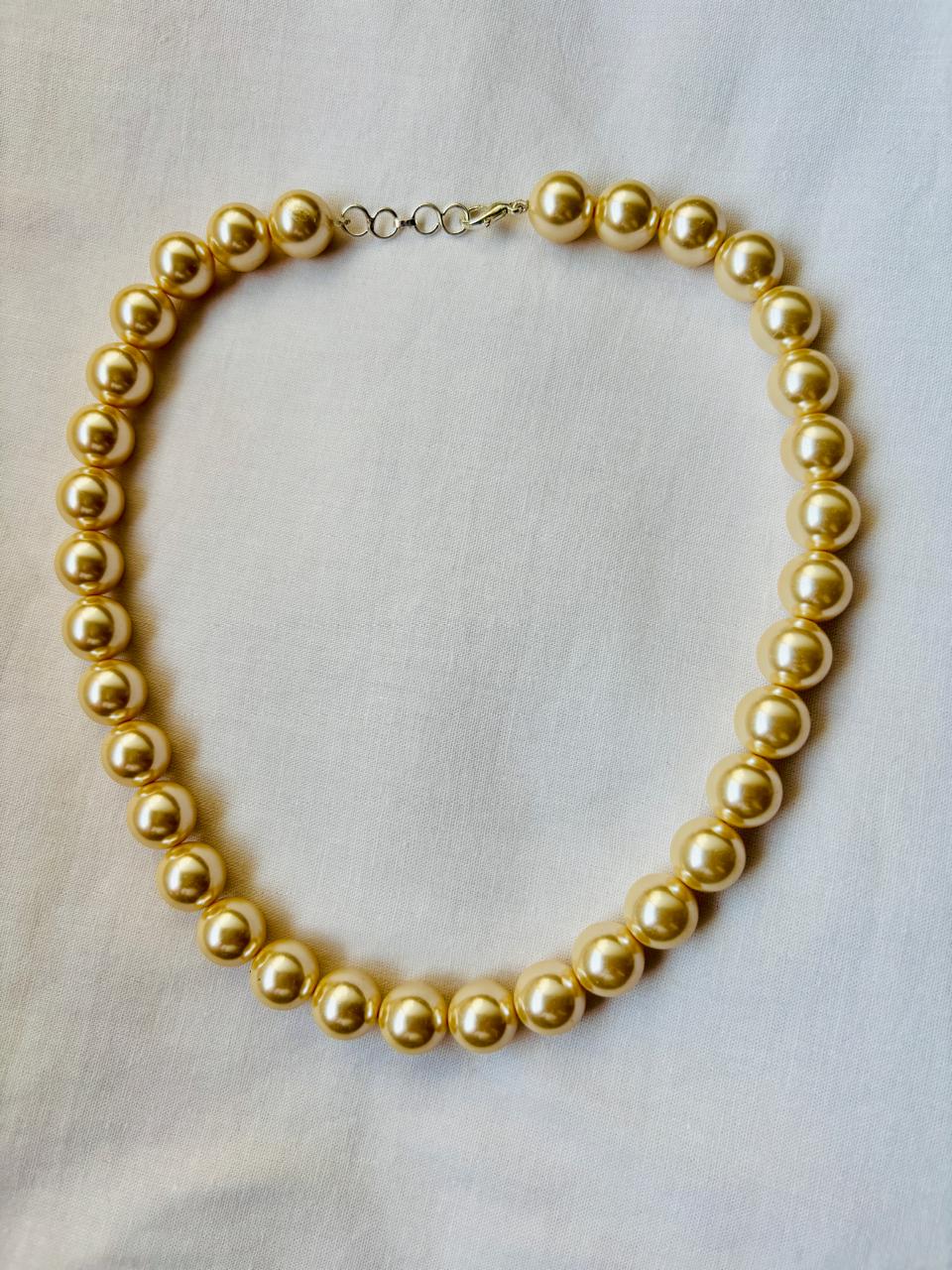 Gold necklace on a light gray background