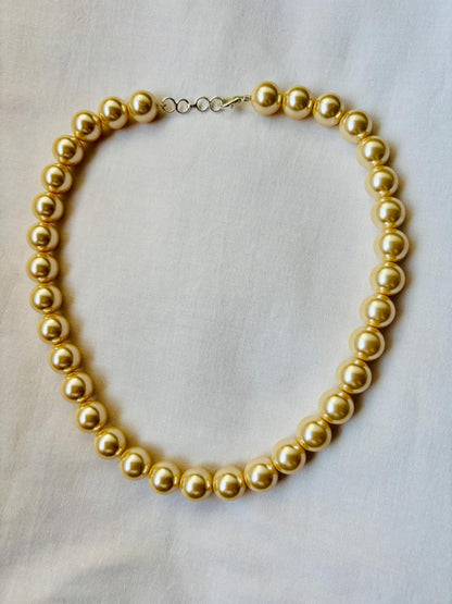 Gold necklace on a light gray background